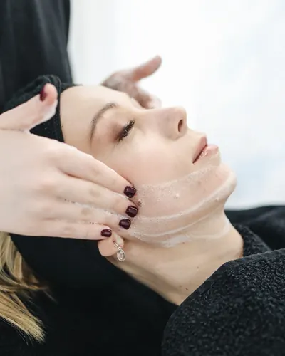 Imagem ilustrativa: massagem facial com as mãos sobre o rosto da cliente