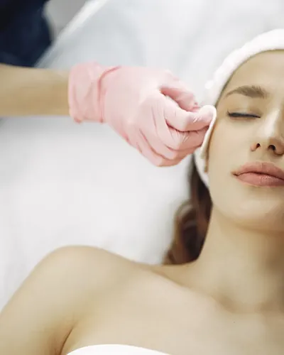 Imagem ilustrativa: cliente de olhos fechados recebendo limpeza de pele